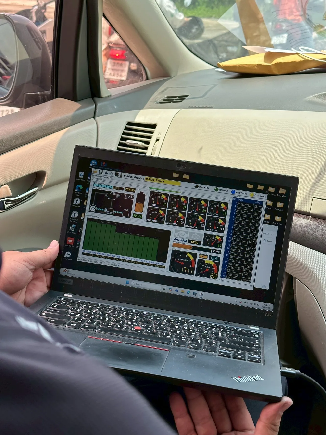 Technician monitoring M-BMS system data inside a vehicle